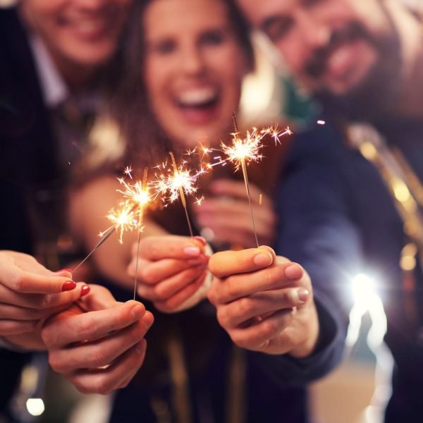 Personas celebrando con bengalas en una fiesta privada.