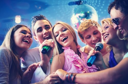 Grupo de personas con micrófonos disfrutando del karaoke en l'Ambient
