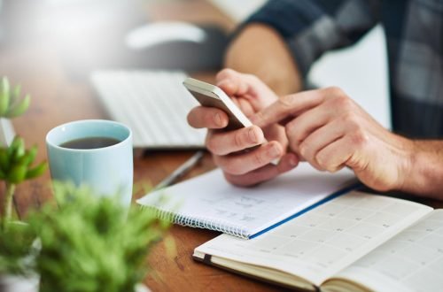 Persona con un teléfono haciendo una reserva en L'Ambient